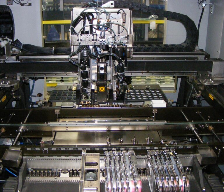 Inside an SMT pick-and-place machine placing components on a PCB panel